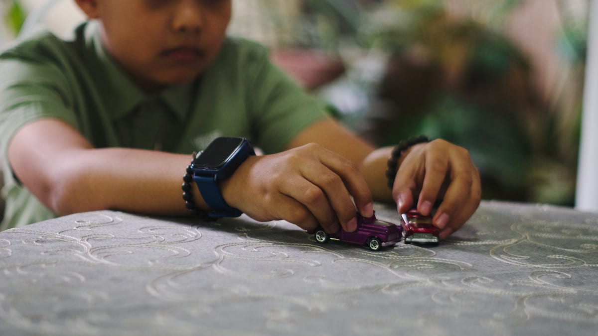 Young boy plays with cars.
