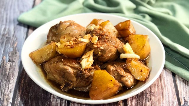 chicken adobo with potatoes in a white plate