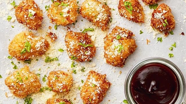 Homemade Chicken Nuggets topped with parmesan cheese on a sheet