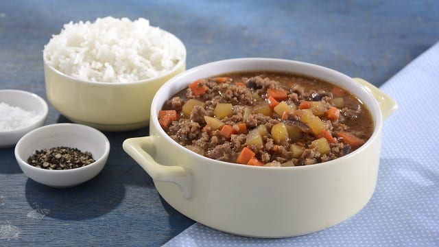 pork giniling na menudo in a bowl with another bowl of rice in the background