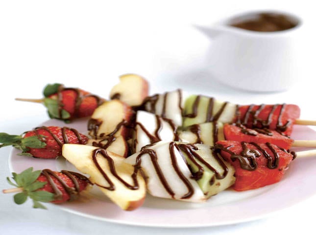 strawberry, kiwi, apples in a fruit kebab drizzled with nutella or chocolate hazelnut spread