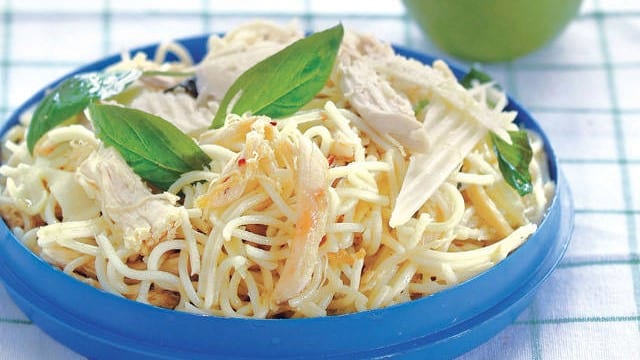 pasta with chicken, garlic, and basil in a blue bowl