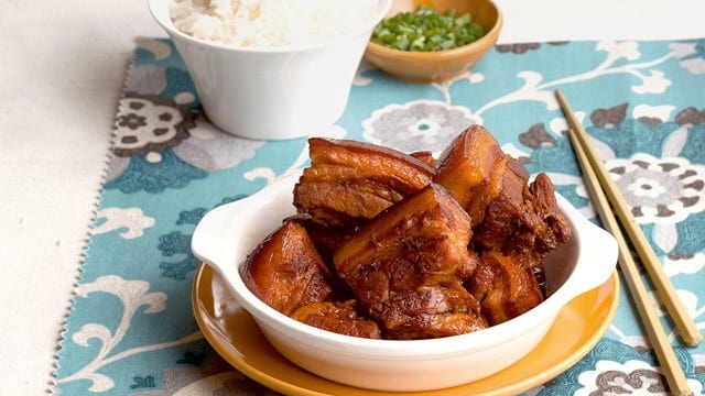 chinese braised pork belly in a white bowl