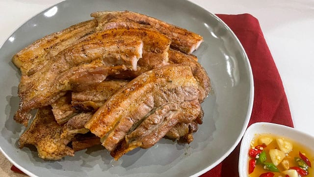 slabs of classic grilled liempo on a gray plate