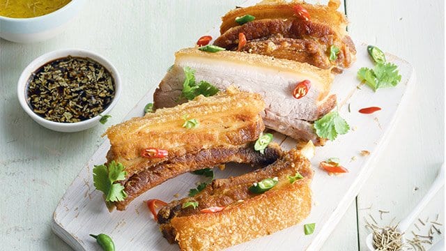 lechon kawali slabs topped with chili slices and chopped spring onion
