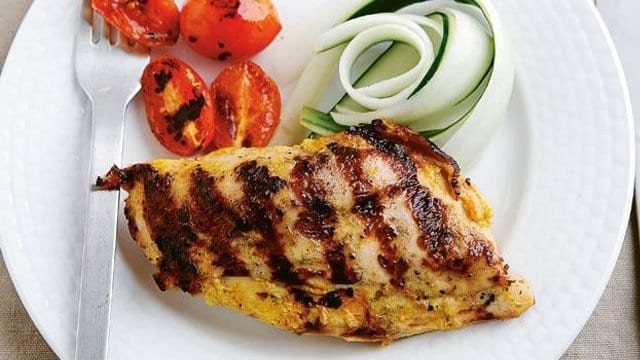 Yogurt and Spice Marinated Chicken with grilled onions and tomatoes on the side